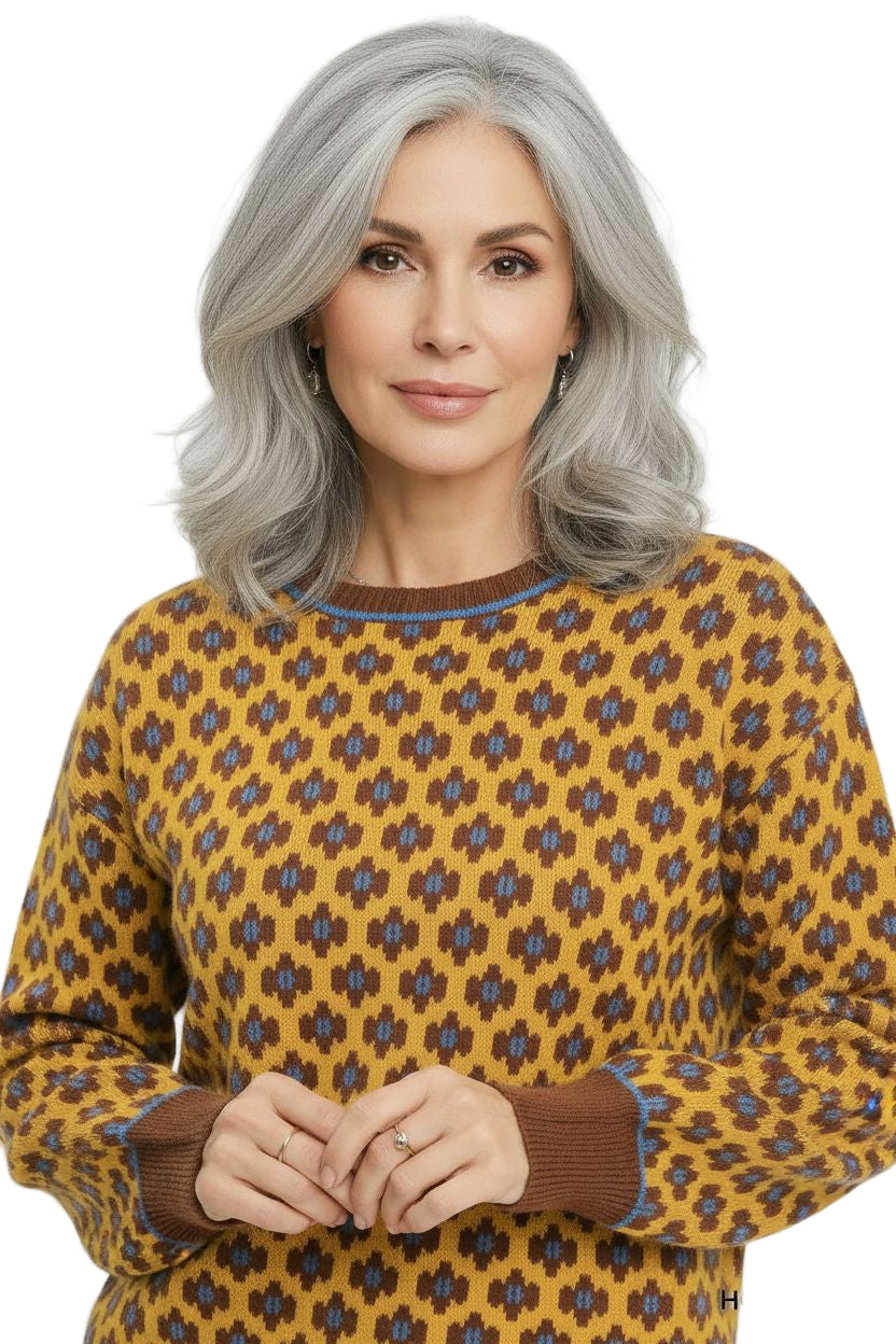 Woman wearing a yellow patterned sweater against a white background