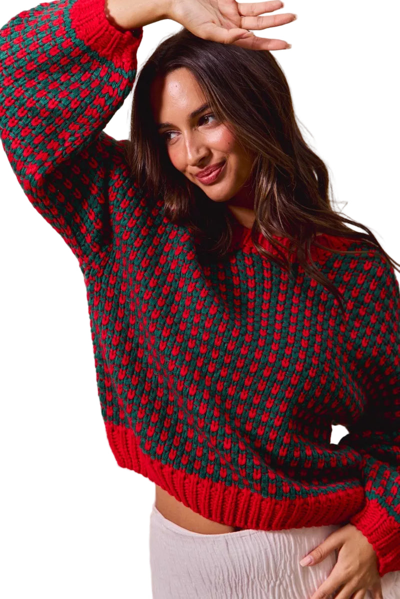 Woman wearing a red and green patterned sweater against a beige background