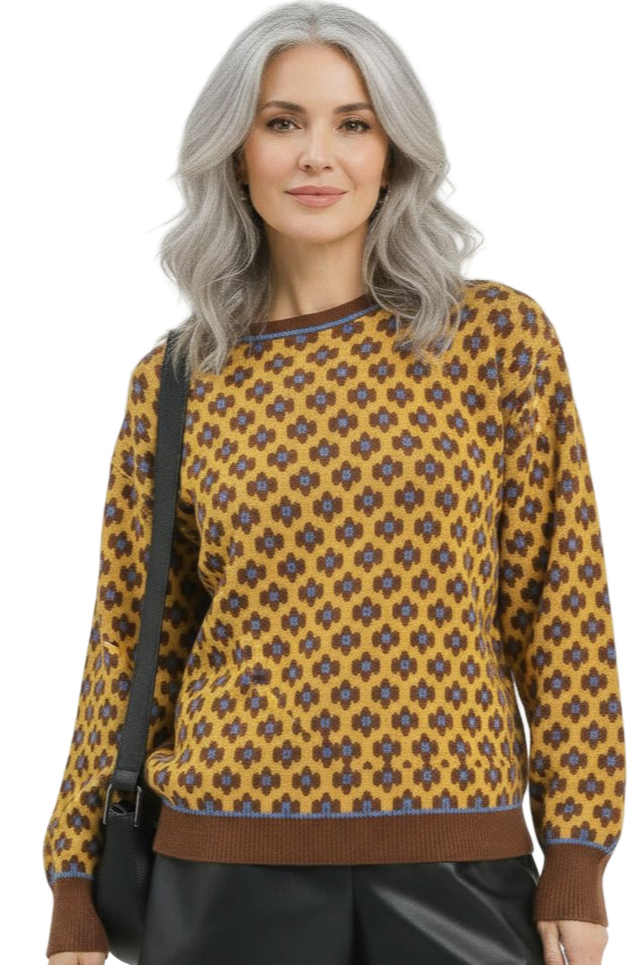 Woman wearing a patterned yellow sweater with a black bag on a white background