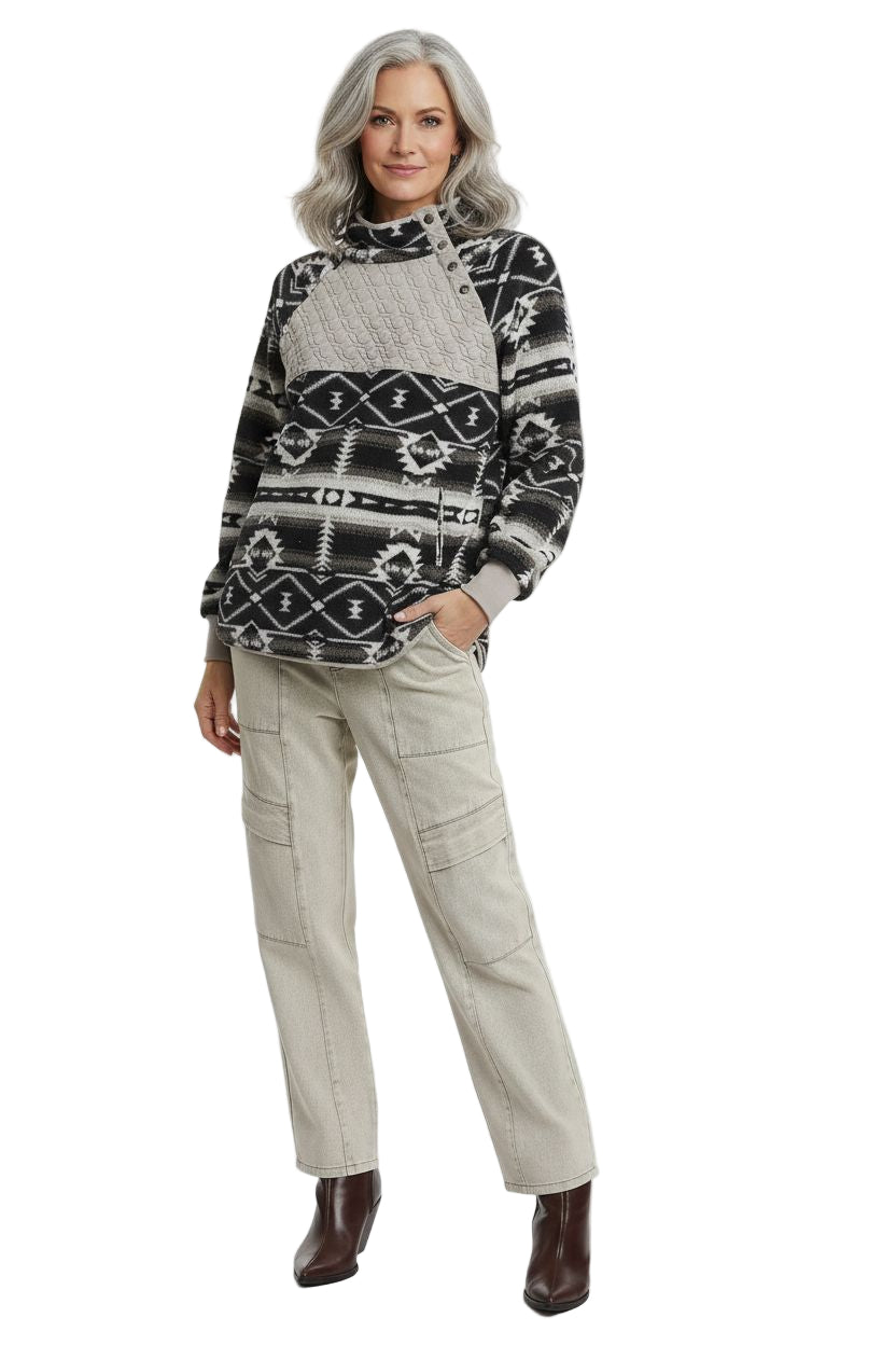 Woman wearing a patterned sweater and beige pants on a white background